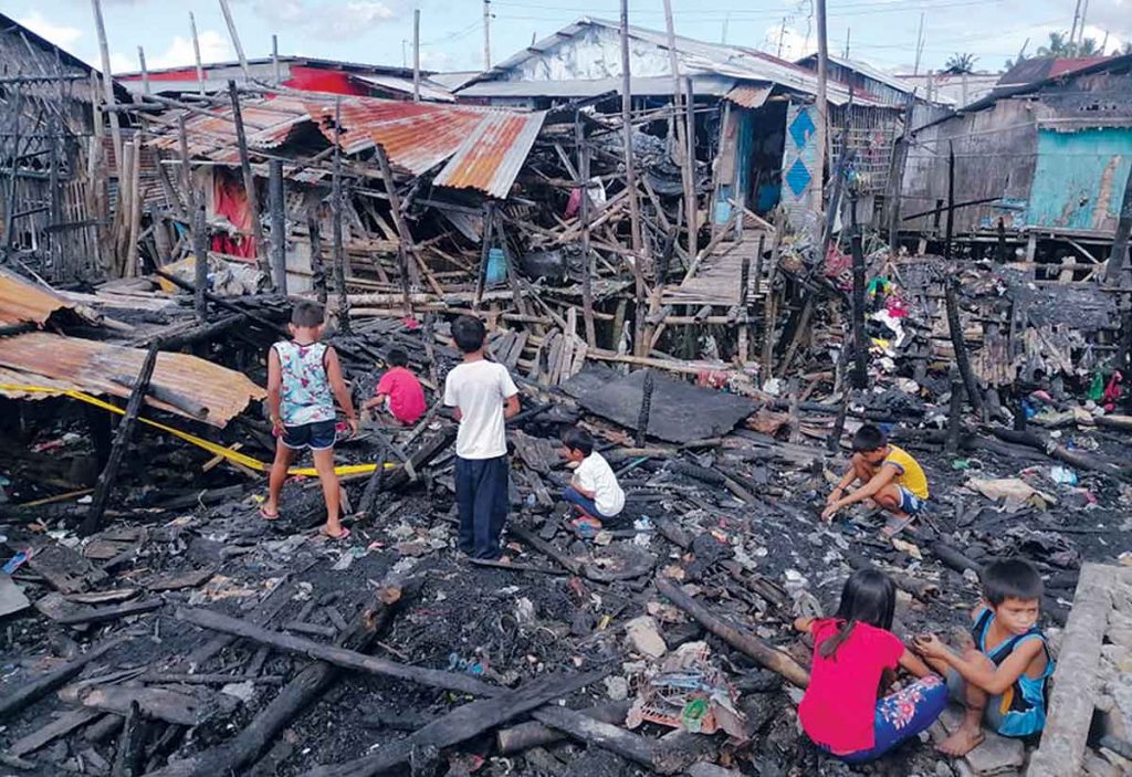 Children are looking for something following a blaze in a slum area of Purok Kitahanon in Bacolod City's Barangay Banago on Thursday night, November 24. (Dominique Gabriel G. Bañaga photo)