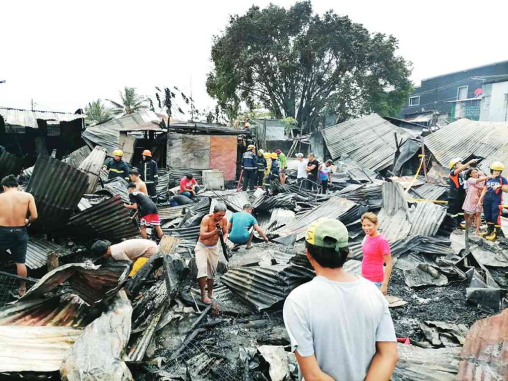 Residents salvage whatever they could use following a fire at Purok Magti-ayon in Bacolod City's Barangay 10 yesterday morning. (Dominique Gabriel G. Bañaga photo)   