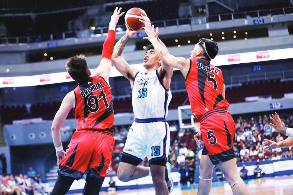 Converge FiberXers’ Justin Arana attempts a two-point shot against two San Miguel Beermen defenders. (PBA photo)