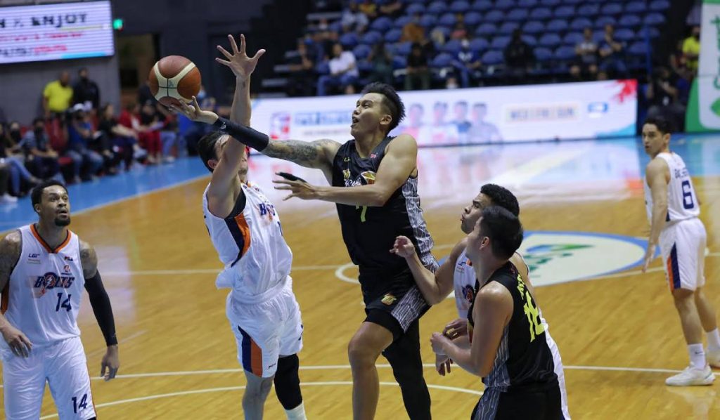 TNT Tropang Giga’s John Paul Erram attempts a reverse basket against the defense of Meralco Bolts’ Clifford Hodge. (PBA photo)