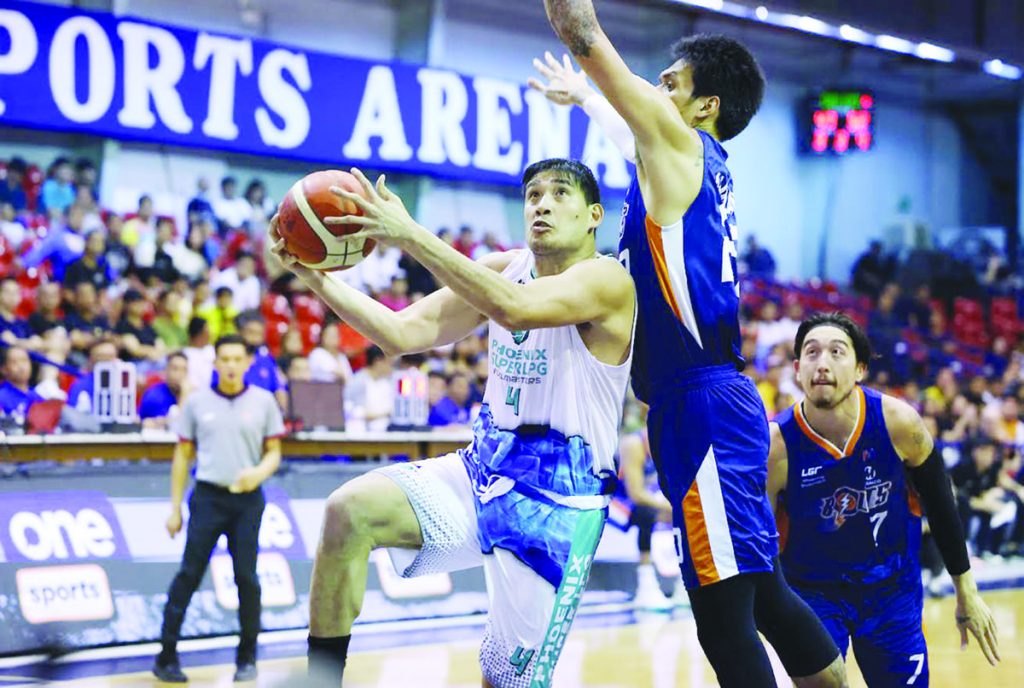 Negrense Raul Soyud of Phoenix Super LPG Fuel Masters goes for a basket against the defense of Meralco Bolts’ Raymond Almazan. (PBA photo)