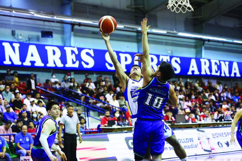 Magnolia Chicken Timplados Hotshots’ Andy Mark Barroca goes for a tough basket against the defense of Converge FiberXers’ Jolo Mendoza. (PBA photo)