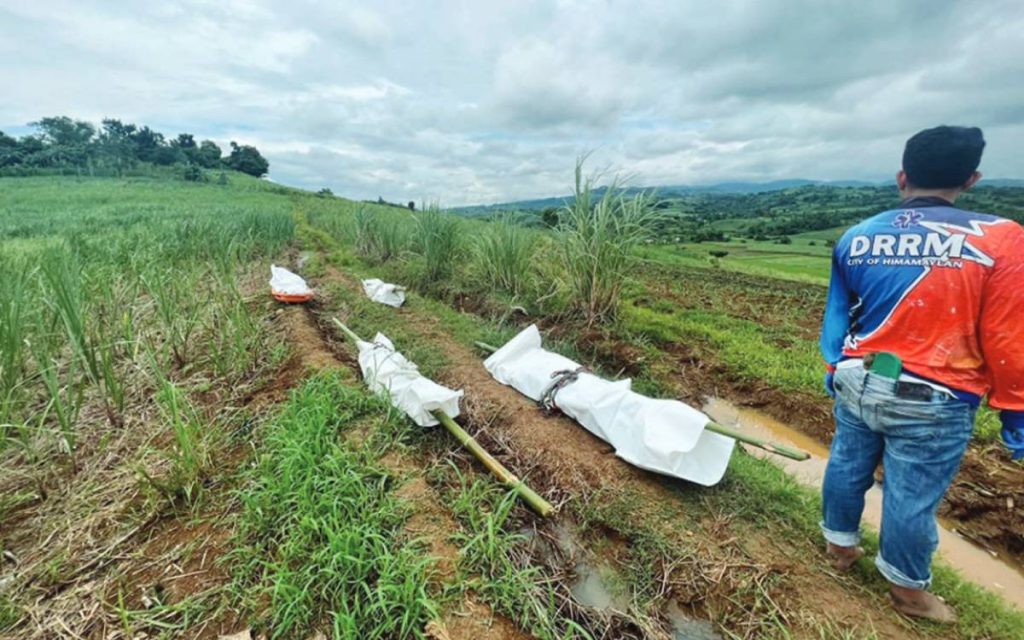 A disaster response personnel retrieves the bodies of a couple and their two children killed by still unidentified perpetrators in Barangay Buenavista’s Sitio Kangkiling in Negros Occidental’s Himamaylan City yesterday, June 15, 2023. The victims sustained head injuries after they were shot at close range, an initial investigation shows. (Himamaylan City Police Station photo)