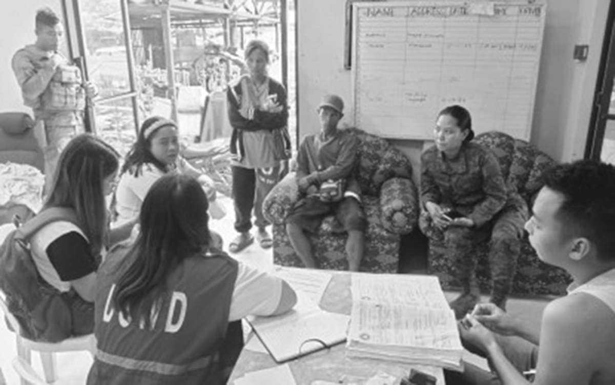 First Lt. Charmaine Sancho (second from right), civil-military operations officer of the 47th Infantry Battalion, helps family members of the slain New People’s Army fighters during the release of the cash assistance by the Department of Social Welfare and Development at Kabankalan City Social Development Welfare Office on Monday, September 25, 2023. Six alleged communist rebels died in a clash with government troops in the hinterlands of Negros Occidental’s Kabankalan City on September 21. (47IB photo)