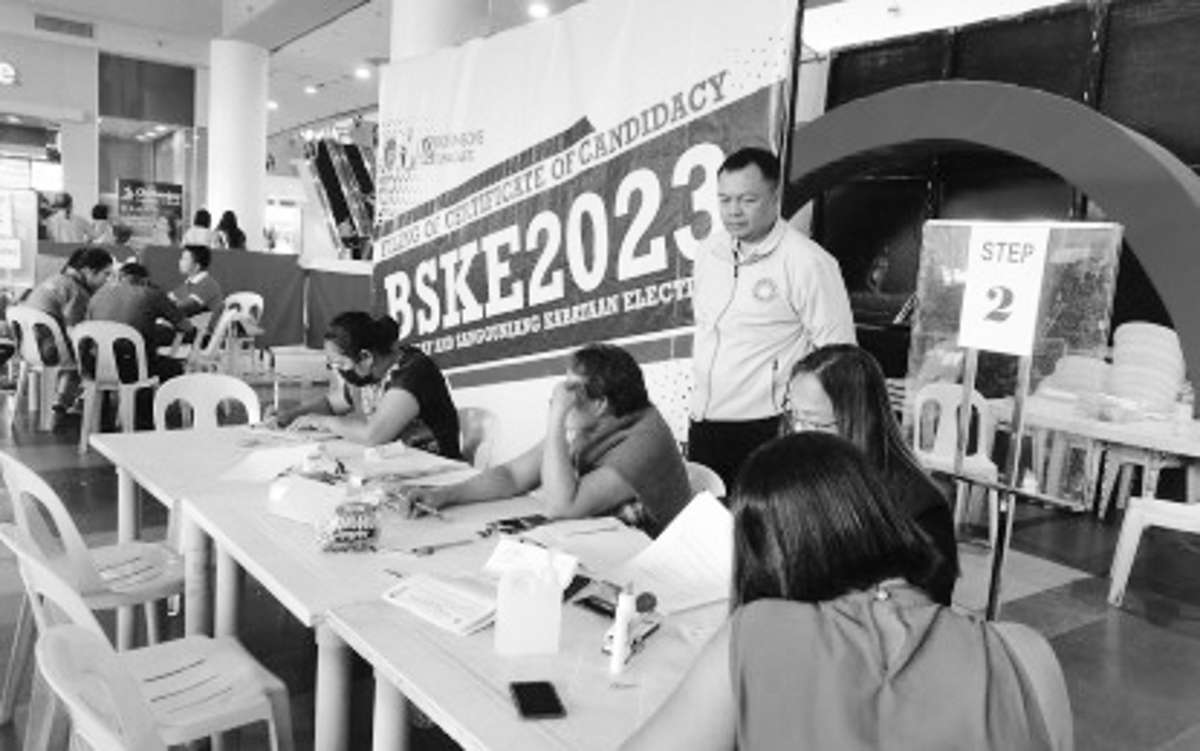 Lawyer Ian Macaraya (standing) silently observes the filing of a certificate of candidacy by an aspirant in the Barangay and Sangguniang Kabataan Elections on Saturday, September 2, 2023, at a mall in Dumaguete City. The filing period from August 28 to September 2 in Negros Oriental was peaceful with no reported untoward incidents, security forces say. (PNA photo)