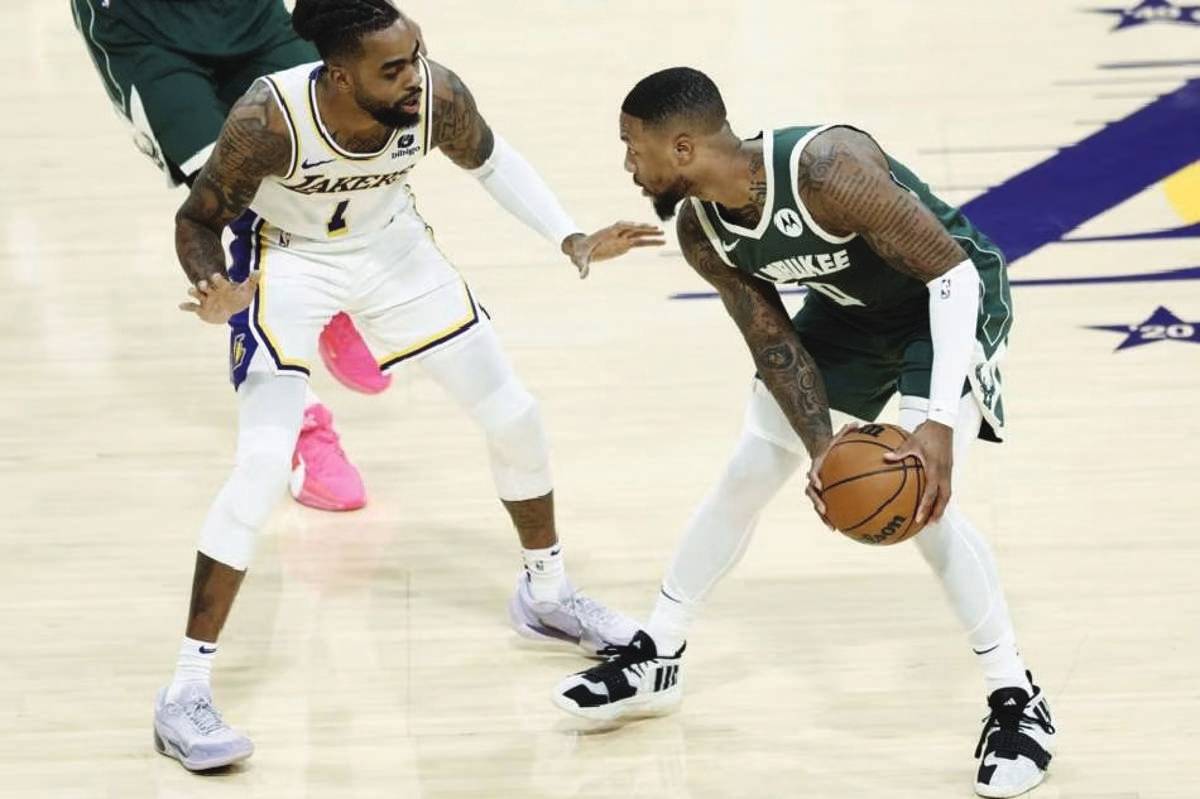 Milwaukee Bucks guard Damian Lillard (right) in action against Los Angeles Lakers guard D'Angelo Russell during the pre-season game at the Crypto.com Arena in Los Angeles, California. (Etienne Laurent EPA-EFE photo)