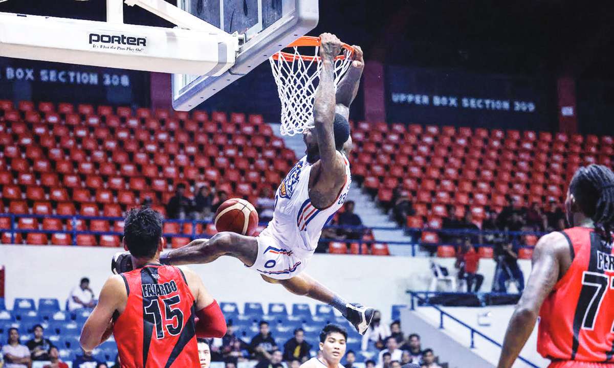 NLEX Road Warriors’ Thomas Robinson hangs on the ring after a two-handed dunk. (PBA photo) 