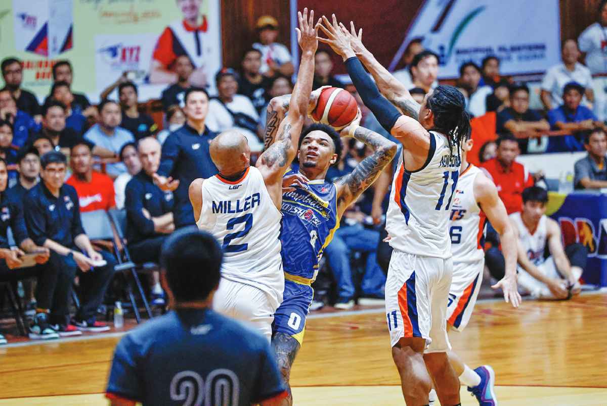 Meralco Bolts’ Chris Newsome and Shonn Miller bother the shot of Magnolia Chicken Timplados Hotshots’ Tyler Bey. (PBA photo)