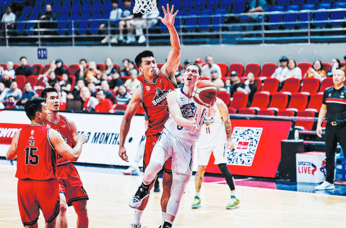 NLEX Road Warriors’ Robert Bolick, Jr. evades the defense of Blackwater Bossing’s Bradwyn Guinto for a layup. (PBA photo)