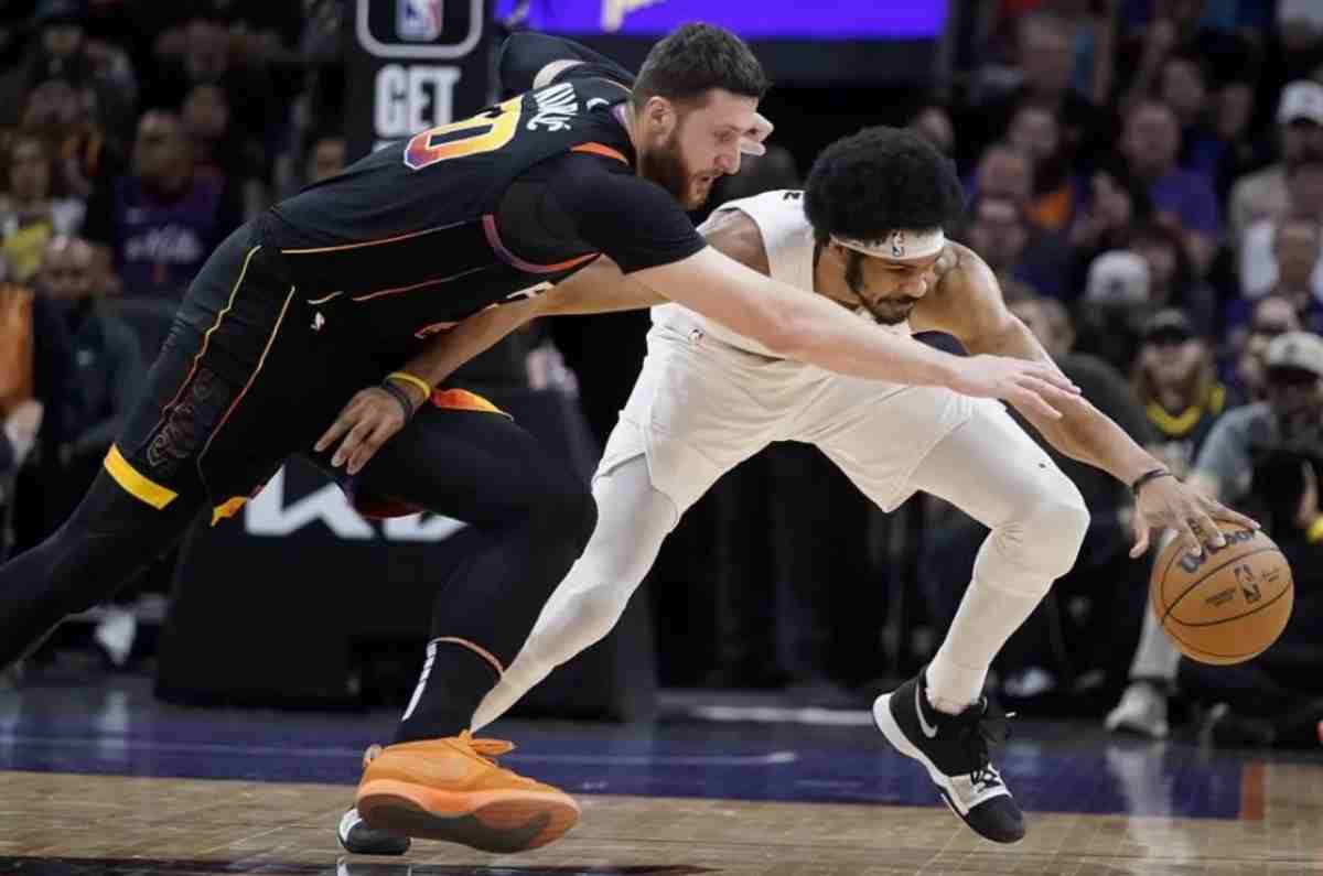 Phoenix Suns center Jusuf Nurkic (left) reaches for the ball, while Cleveland Cavaliers center Jarrett Allen gets a hand on it during the first half of an NBA game. (Darryl Webb / AP photo)