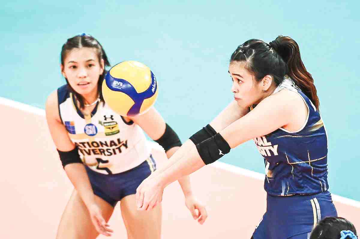 National University Lady Bulldogs’ Mhicaela Belen saves the ball as Negrense Shaira Jardio looks on. (UAAP photo)