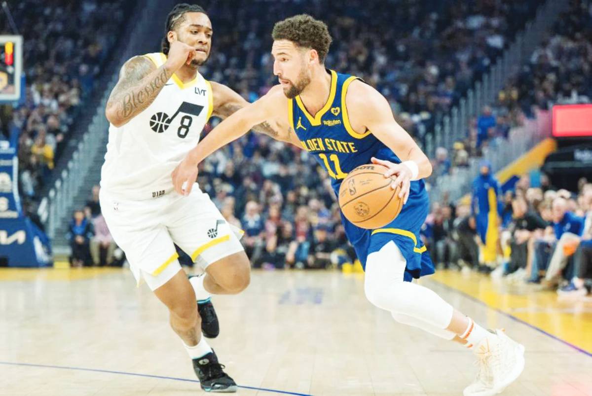 Golden State Warriors guard Klay Thompson (right) drives the ball past Utah Jazz forward Brice Sensabaugh during the first half of an NBA game in San Francisco. (Nic Coury / AP photo)