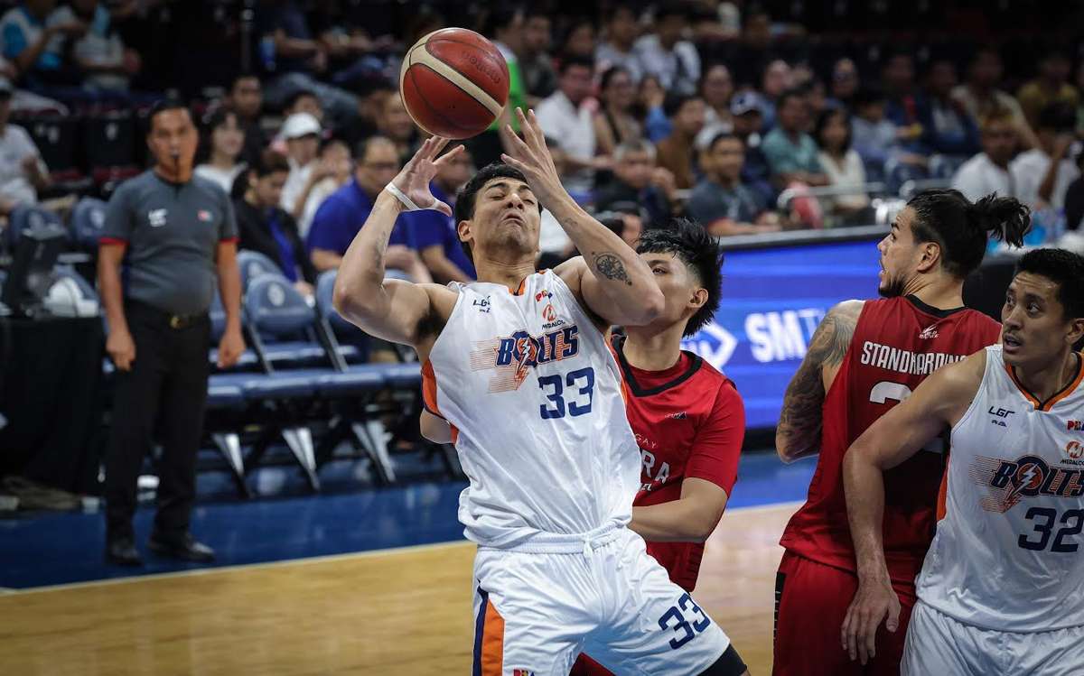 Meralco Bolts’ Brandon Bates loses the ball after being bothered by the defense of Barangay Ginebra San Miguel Kings’ Ralph Cu. (PBA photo)