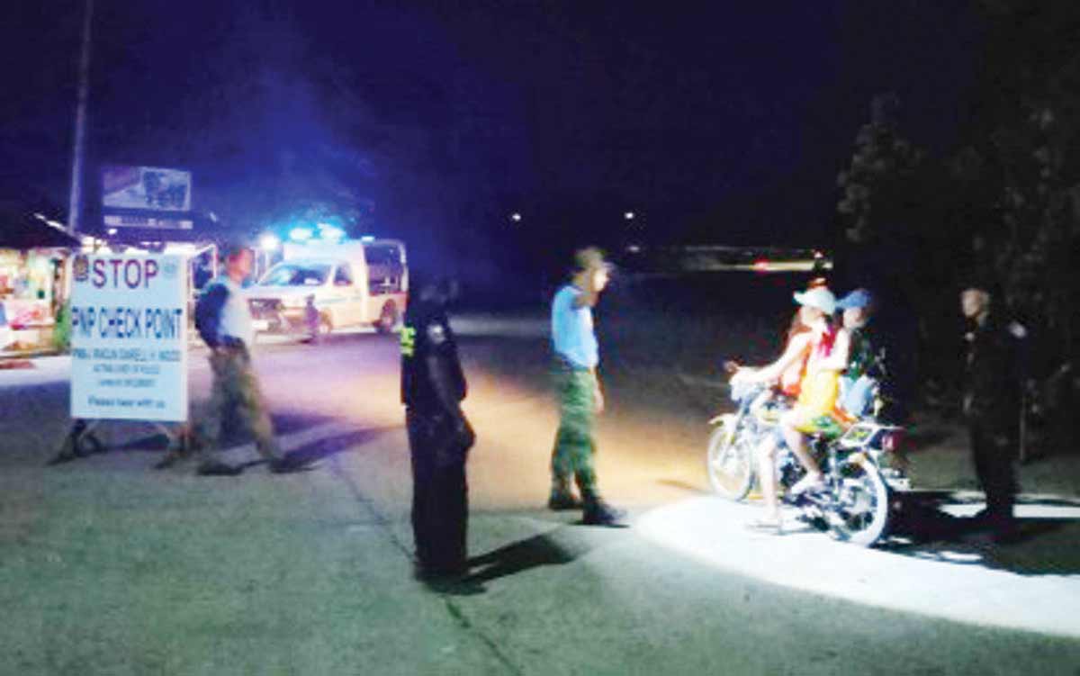 Police personnel man the checkpoint in La Castellana, the locality worst hit by the eruption of Mt. Kanlaon in Negros Occidental, on June 6, 2024. A curfew for individuals in public places will be enforced from 9:00 p.m. to 4:00 a.m. “to regulate public and non-essential activities to ensure the safety of residents and to support the anti-criminality effort of the Philippine National Police during these times.” (La Castellana Municipal Police Station photo)