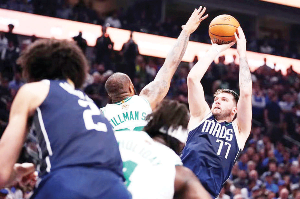 Dallas Mavericks guard Luka Doncic (right) shoots over Boston Celtics forward Xavier Tillman. (Julio Cortez / AP photo) 