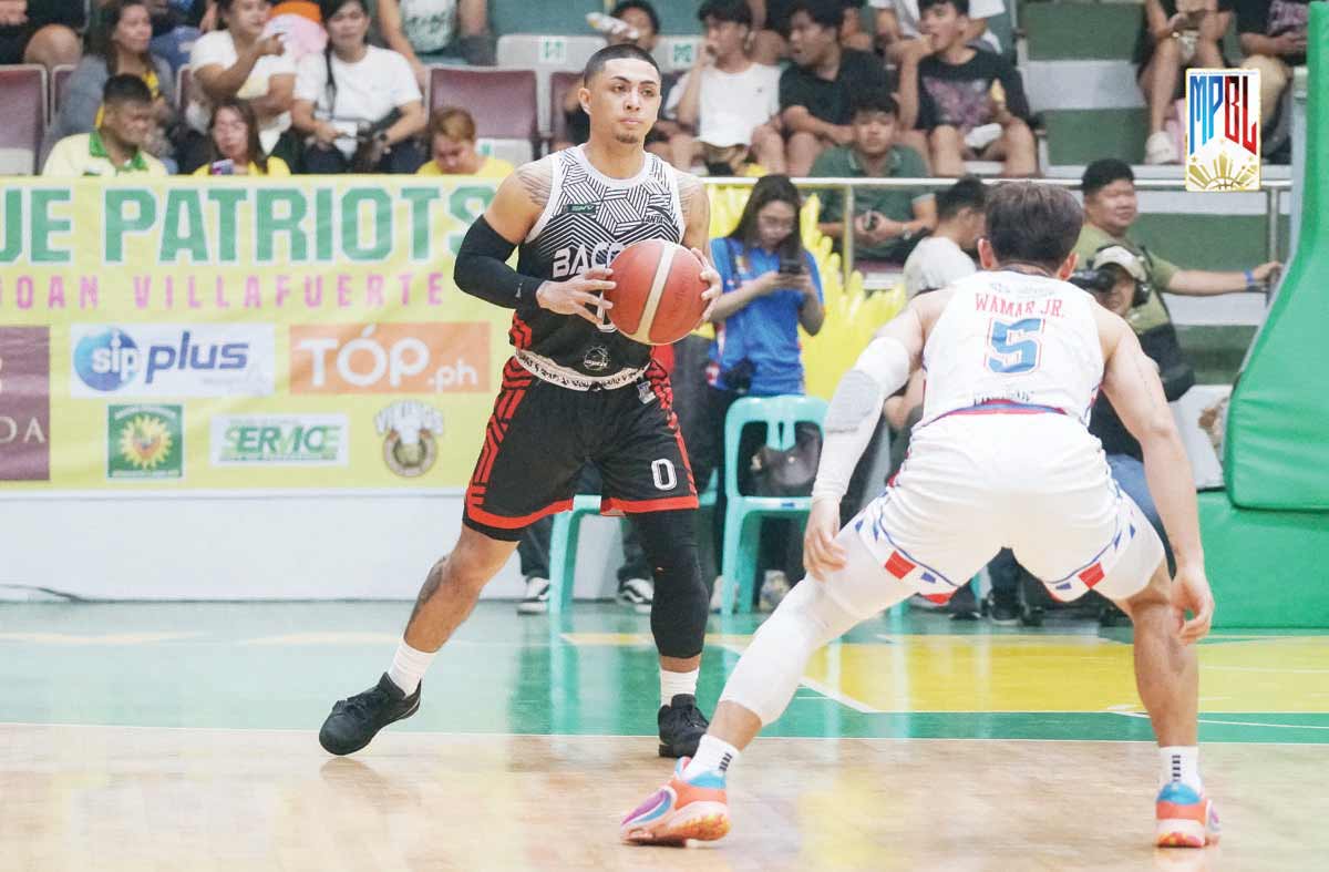 Bacolod City of Smiles’ Jamel Ramos holds the ball while being defended by San Juan Knights-Go for Gold’s Orlan Wamar, Jr. (MPBL photo)