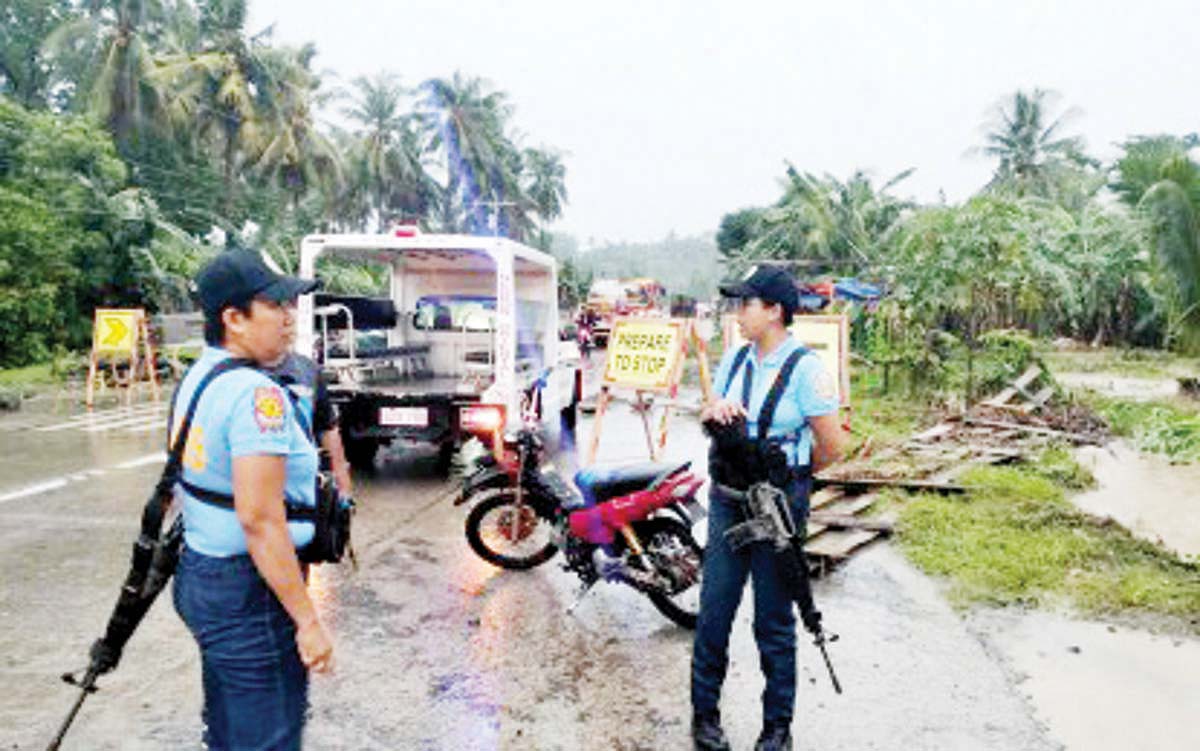 Police personnel in Bindoy, Negros Oriental step up their watch after heavy rains triggered flash floods on Monday afternoon, July 8, 2024. A 70-year-old man died after he was carried downstream by floodwaters while 40 families were evacuated to a safer place. (Bindoy police photo)