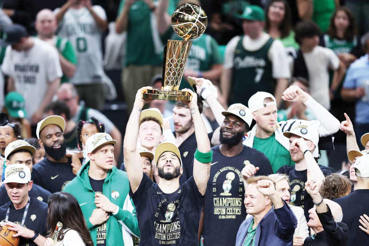 Jayson Tatum (center) of the Boston Celtics lifts the Larry O’Brien Championship Trophy after Boston's 106-88 win against the Dallas Mavericks in Game 5 of the 2024 NBA finals at TD Garden on June 17, 2024. (Adam Glanzman / Getty Images / AFP photo)