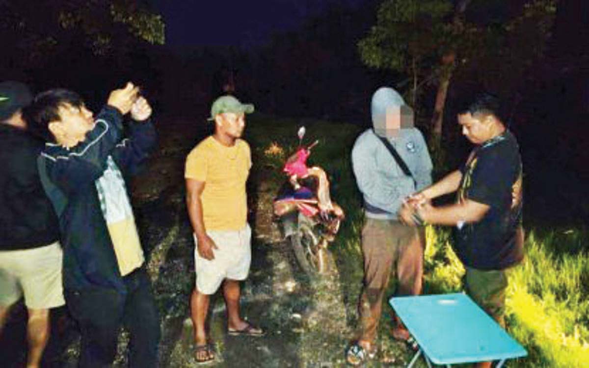 Police operatives arrest a suspected drug pusher (in a hoodie) during a buy-bust in Barangay Cangmating, Sibulan, Negros Oriental close to midnight on Friday, July 19, 2024. Seized from him was suspected shabu with an estimated street value of P2.87 million. (Negros Oriental Police Provincial Office photo)