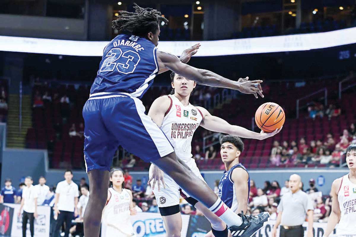 Bacolodnon Harold Alarcon of the University of the Philippines Fighting Maroons protects the ball from Adamson University Falcons’ OJ Ojarike. (UAAP photo)