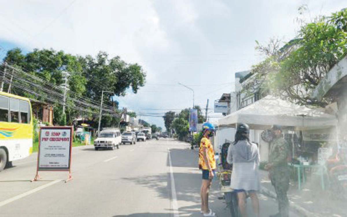 A police officer checks motorist credentials at a checkpoint in this undated photo. The National Police Commission in Negros Oriental is enhancing the Community Service-Oriented Policing Program in various towns and cities to address criminality. (PNA / File photo)