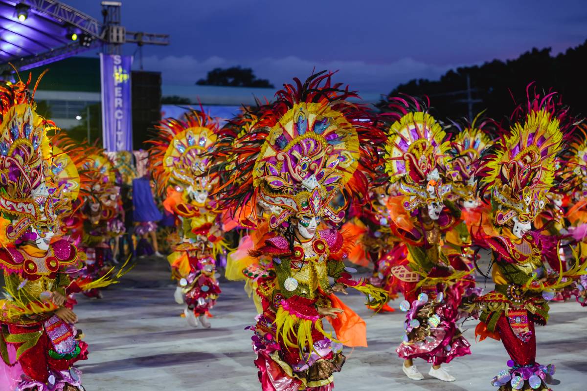 MassKara dancers in colorful masks gracing the crowd during the MassKara Arena Competition.