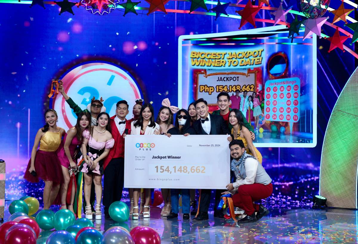 Bingo Mega jackpot winner with BingoPlus hosts cheerfully posing for a souvenir photo