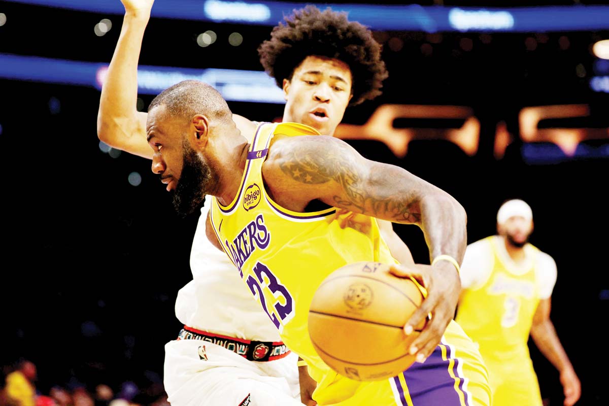 Los Angeles Lakers forward LeBron James dribbles the ball against Memphis Grizzlies forward Jaylen Wells during the first quarter of an NBA game. (Kiyoshi Mio-Imagn Images / Reuters photo)