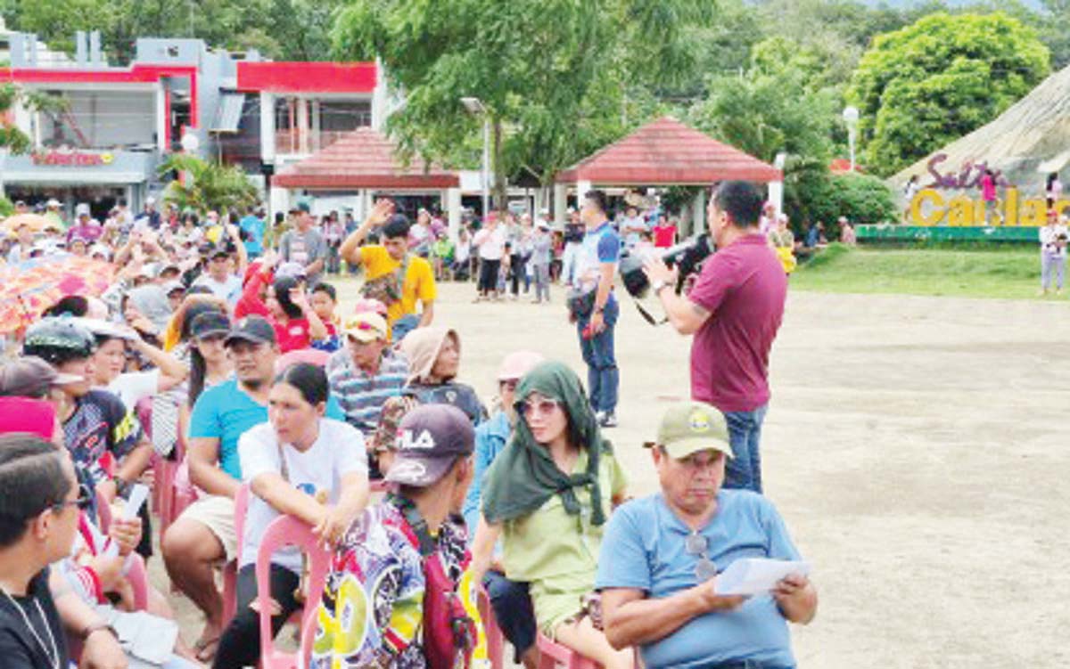 Canlaon City Mayor Jose Chubasco Cardenas (with megaphone) addresses evacuees during the distribution of cash assistance on Thursday, December 26, 2024. Since the December 9 eruption of Mt. Kanlaon, 2,421 families or 7,816 individuals have sought shelter in evacuation centers and other temporary accommodations. (SALTA Canlaon Official Facebook photo)