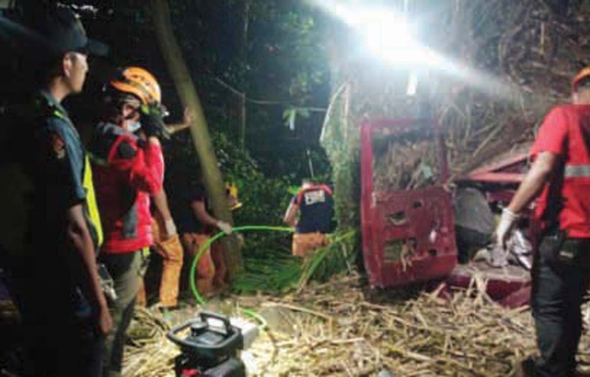 Emergency responders rush to the site where a long bed truck loaded with sugarcane fell off a bridge in Barangay Tamisu, Bais City in Negros Oriental early morning yesterday, January 24, 2025. The driver and three passengers of the truck were seriously injured and brought to the hospital. (Negros Oriental Police Provincial Office photo)