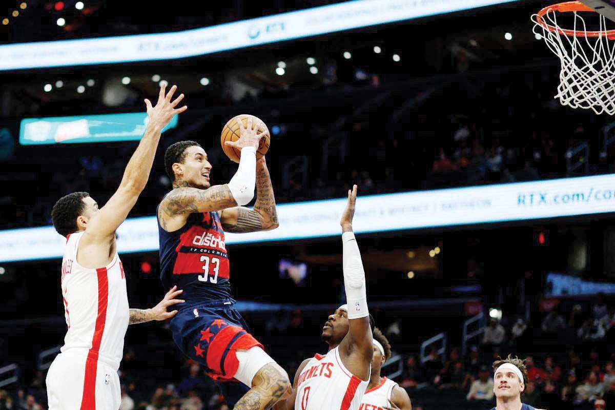 Washington Wizards forward Kyle Kuzma (33) drives to the basket as Houston Rockets guards Fred VanVleet (5) and Aaron Holiday defend. (Geoff Burke-Imagn Images / Reuters photo)