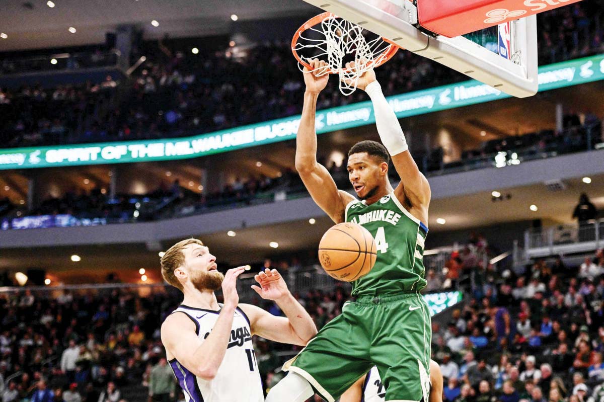 Milwaukee Bucks forward Giannis Antetokounmpo (right) dunks the ball against Sacramento Kings center Domantas Sabonis. (Benny Sieu-Imagn Images / Reuters photo)