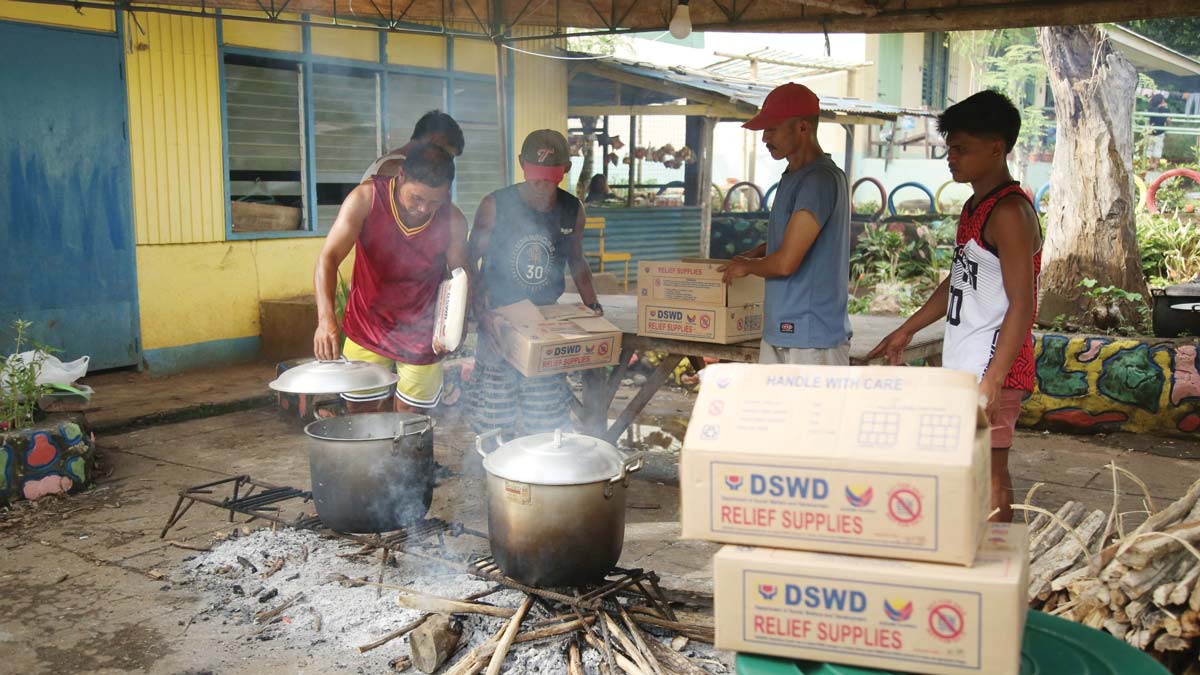 Internally displaced persons in Camp 9 at Linothangan Elementary School prepare food for dinner in their community kitchen. (PIA-Negros Oriental photo)