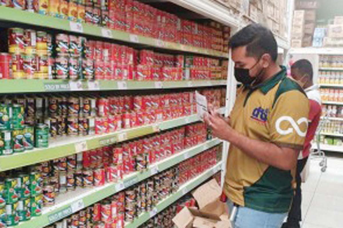 A staff of the Department of Trade and Industry (DTI) checks the prevailing prices of goods at a grocery store in this undated photo. The DTI-Negros Oriental has approved a price freeze for basic commodities after the province was placed under a state of calamity due to the restive Mt. Kanlaon. (DTI-Negros Oriental / File photo)