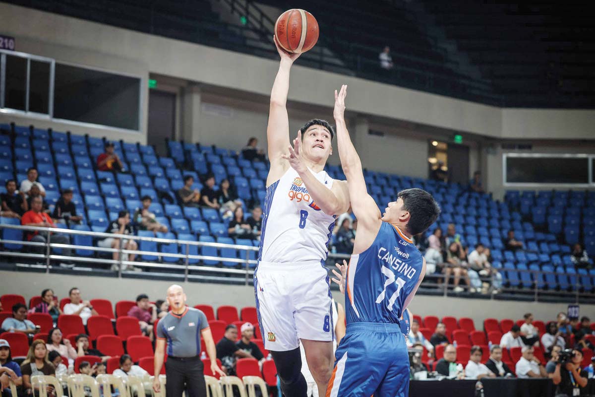 Negrense Calvin Oftana of the TNT Tropang Giga goes for a one-hander against the defense of Meralco Bolts’ CJ Cansino. (PBA photo)