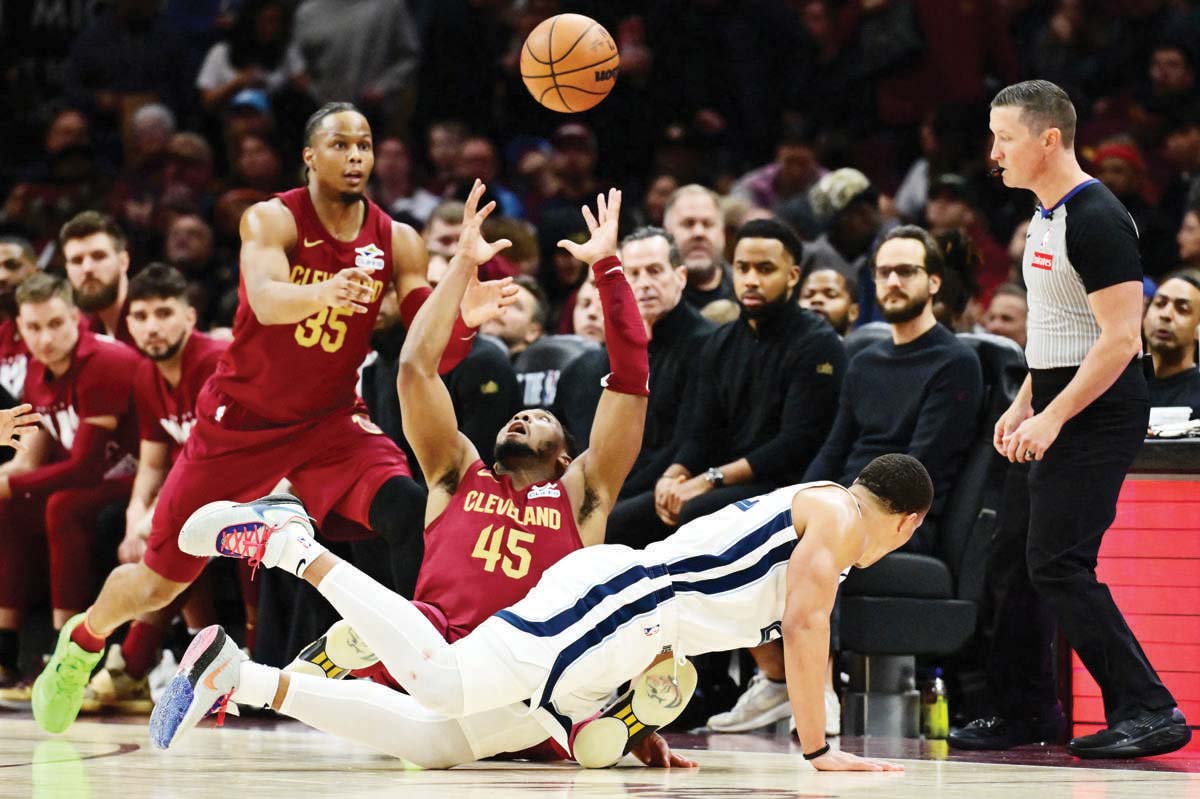 Cleveland Cavaliers guard Donovan Mitchell (45) goes for a loose ball as forward Isaac Okoro (35) looks on. (Ken Blaze-Imagn Images)