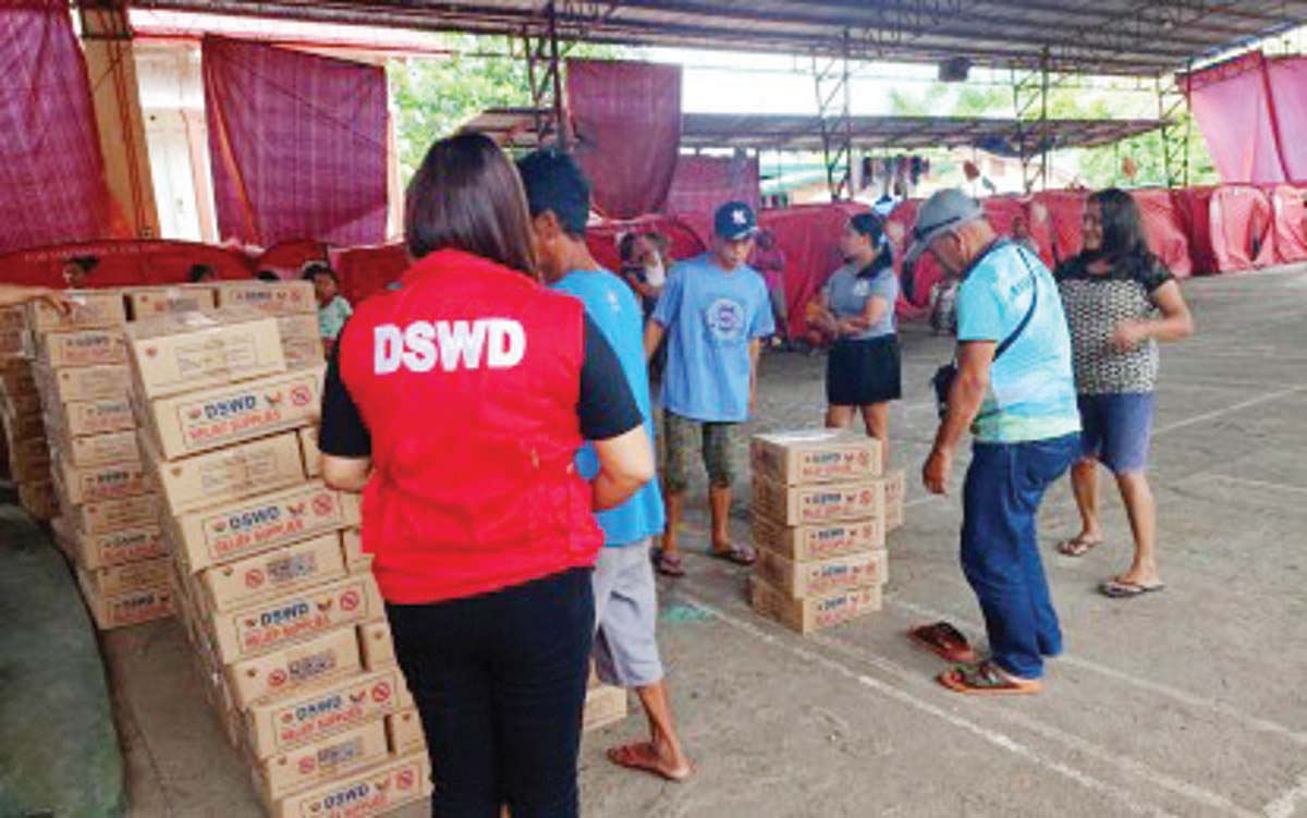 Department of Social Welfare and Development (DSWD) personnel assist in the distribution of family food packs for displaced residents staying at La Castellana Elementary School in Negros Occidental on February 7, 2025. The DSWD reported that P2.782 billion in standby funds and relief stockpile are being prepared as a response to the ongoing threat of Mt. Kanlaon eruption in Negros Island. (DSWD-Western Visayas photo)