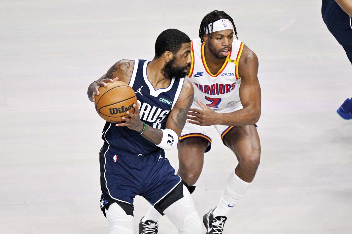 Dallas Mavericks guard Kyrie Irving (left) looks to move the ball past Golden State Warriors guard Buddy Hield. (Jerome Miron-Imagn Images / Reuters photo)