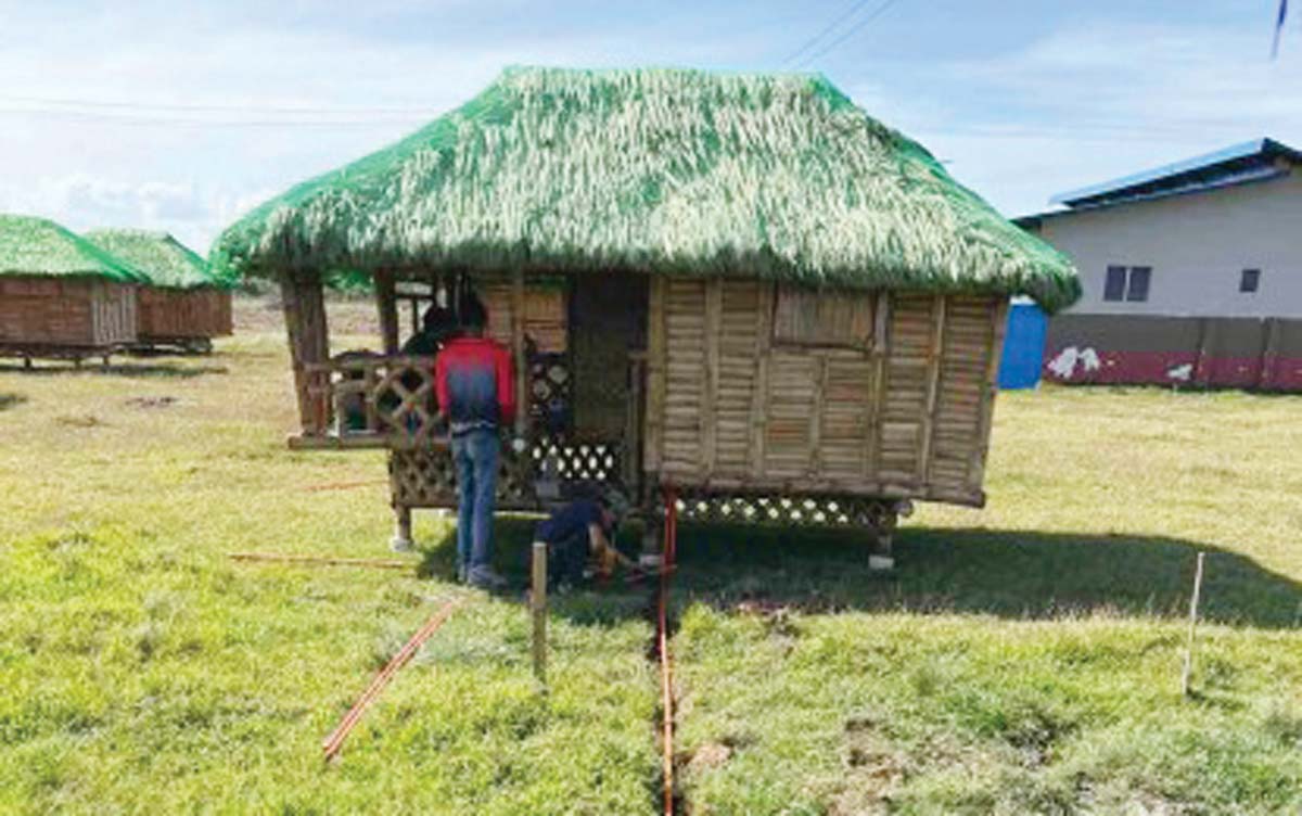 Electrical connections are being installed in nipa huts being set up as a temporary relocation shelter for families displaced by the eruption of Mt. Kanlaon in Bago City, Negros Occidental, in this photo dated February 4, 2025. At least 33 out of 50 bahay kubo units have been set up at the Payag sang Kapag-on Village in the city’s relocation site in Barangay Napoles. (Office of Civil Defense photo)