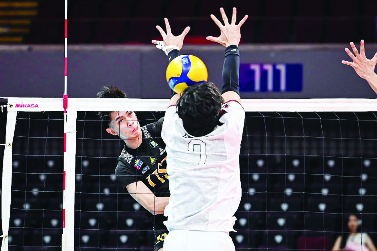 Negrense JayRack dela Noche of the University of Santo Tomas Golden Spikers scores against a defender. (UAAP photo)