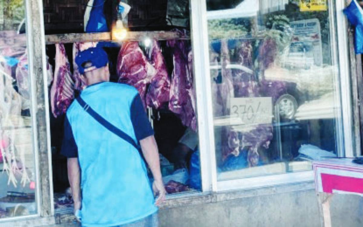 A customer inquires about pork prices at a stall in Dumaguete City, Negros Oriental in this undated photo. The Provincial Veterinary Office is facilitating hog farmers and traders to reach a fair price agreement to bring down the high prices of pork in local markets. (PNA photo)