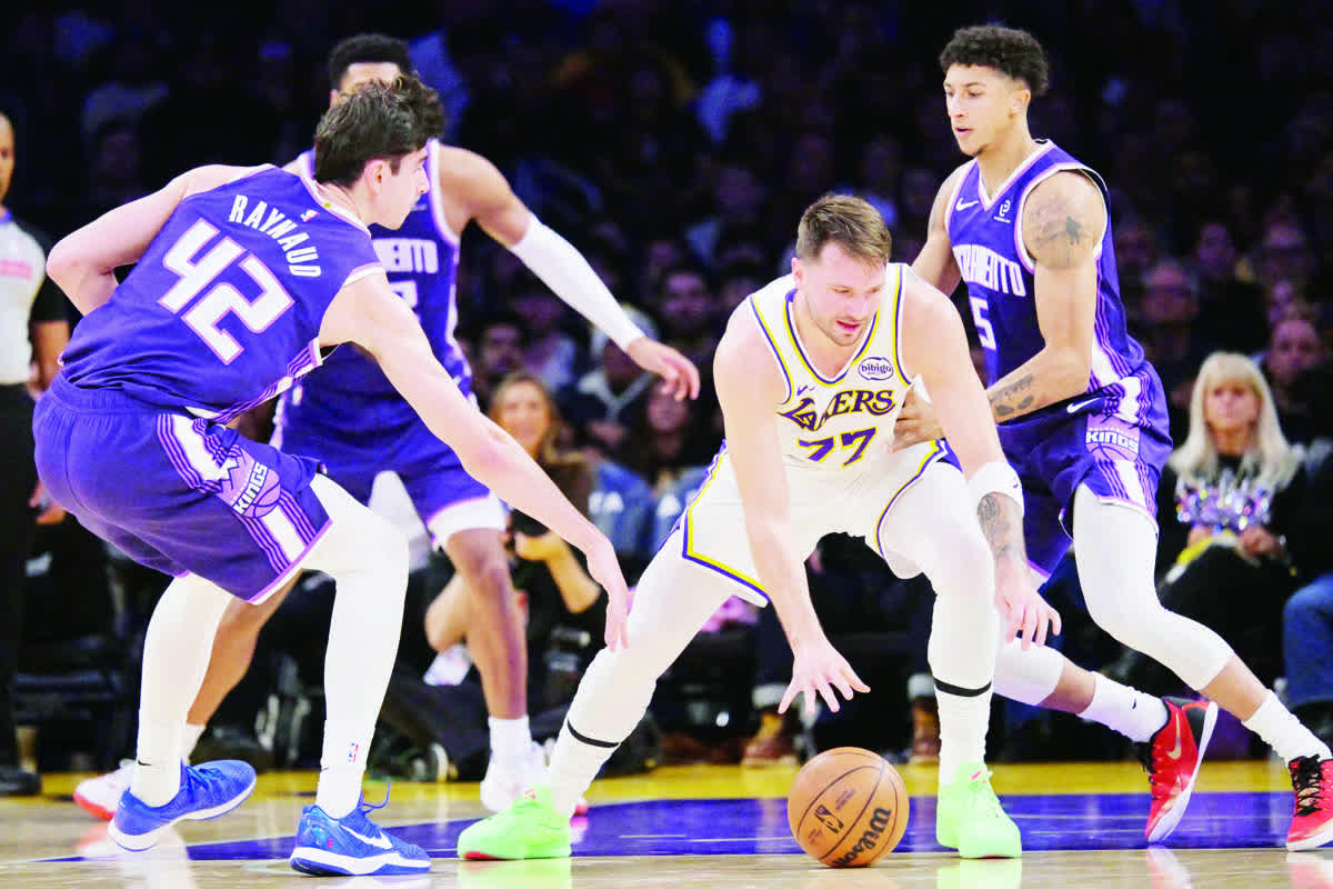 Sacramento Kings center Maxime Raynaud (42) and guard Nique Clifford (5) defend against Los Angeles Lakers guard Luka Doncic (77) in the first half. (Jayne Kamin-Oncea / Imagn Images)