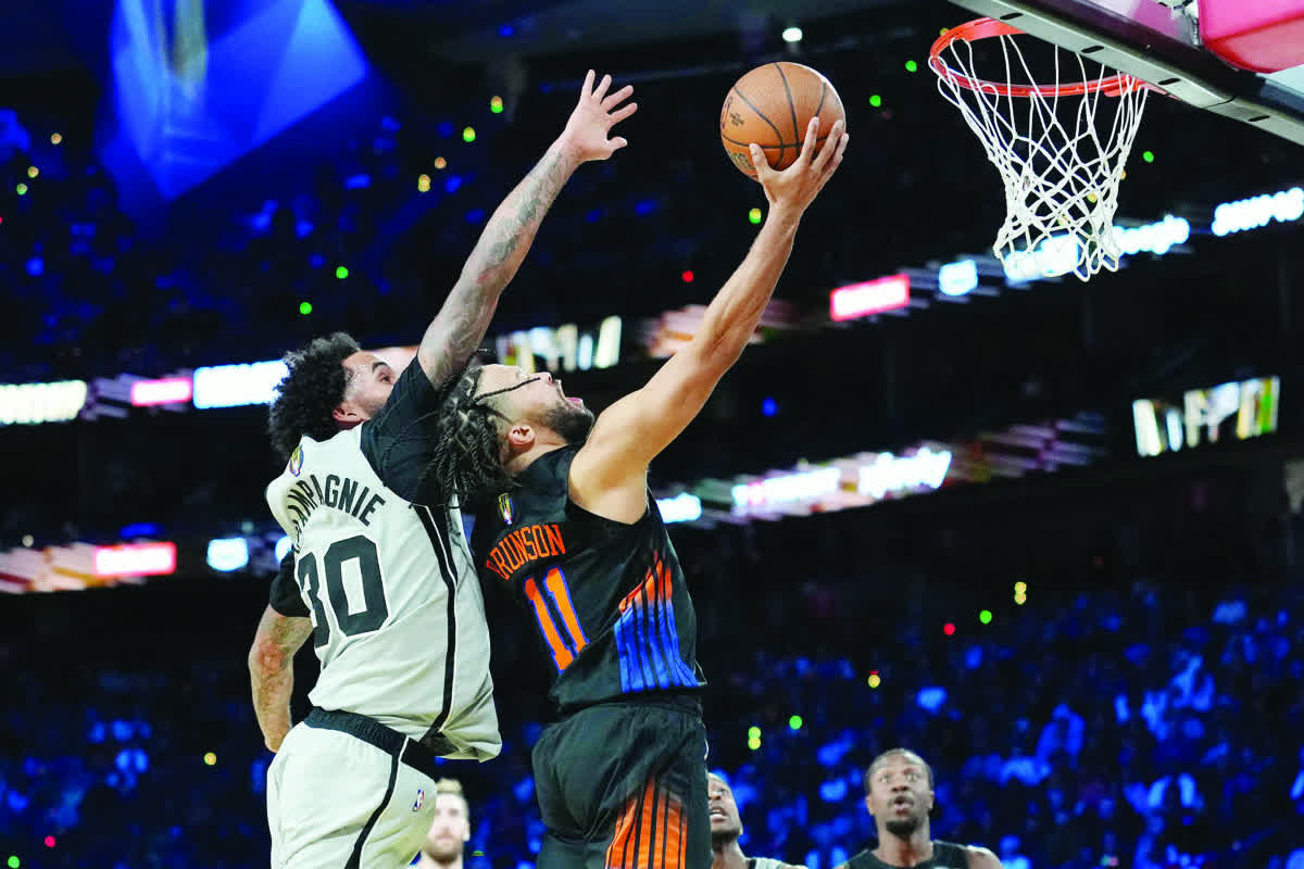 New York Knicks guard Jalen Brunson (right) shoots the ball over San Antonio Spurs forward Julian Champagnie. (Kirby Lee / Imagn Images)