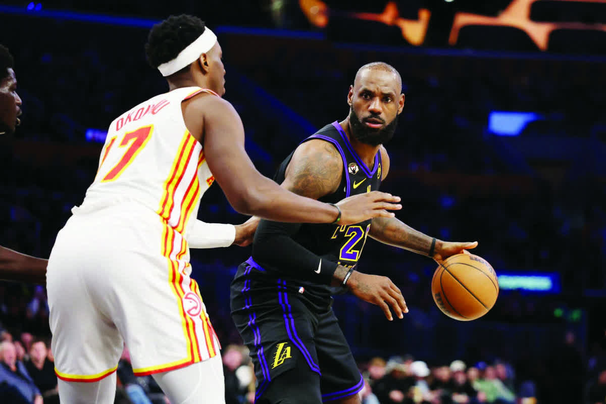 Los Angeles Lakers forward LeBron James (right) looks to pass the ball against Atlanta Hawks forward Onyeka Okongwu. (Kiyoshi Mio / Imagn Images)