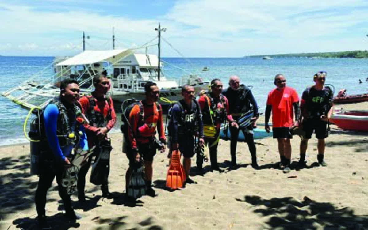 Coast Guard personnel and private scuba divers gear up for another dive in search of a missing foreigner in Dauin, Negros Oriental in April 2025. The Coast Guard clarified that dive boats or motorboats that ferry passengers or tourists are limited to travel only within destinations specified by the Certificate of Public Convenience issued by the Maritime Industry Authority. (PNA / File photo)