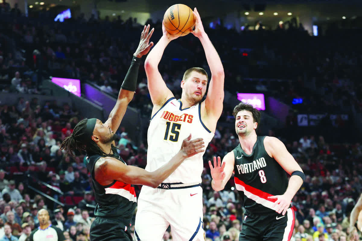 Denver Nuggets center Nikola Jokic (center) grabs a rebound over Portland Trail Blazers guard Jrue Holiday and forward Deni Avdija. (Jaime Valdez / Imagn Images / Reuters)