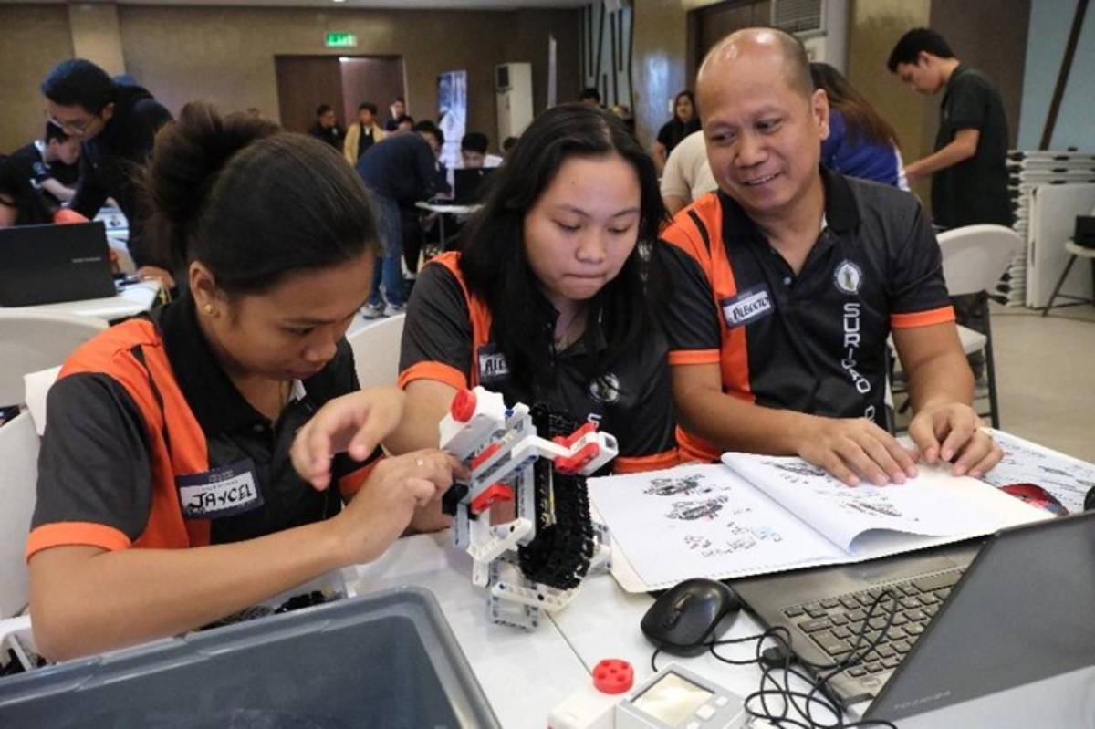 EMPOWERING FUTURE INNOVATORS THROUGH HANDS-ON LEARNING: Participants engage in a collaborative robotics session, applying their technical skills and creativity to build and program their own models. Alberto S. Elcullada, Jr., Teacher III from Surigao del Norte, guides his students, ensuring the activity fosters critical thinking, teamwork, and problem-solving, key competencies in preparing learners for the future of technology.
