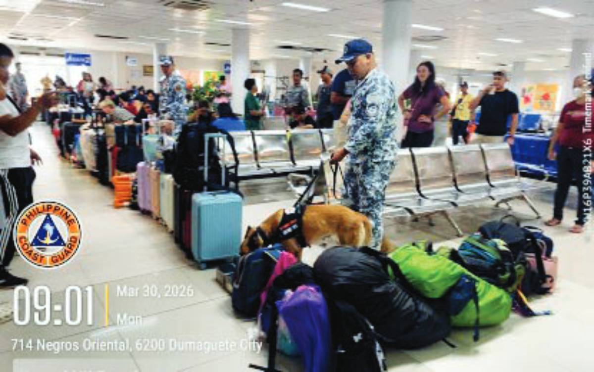 A Philippine Coast Guard personnel and a sniffing dog conduct rounds at the passenger terminal in Dumaguete City on Monday, March 30, 2026. The Coast Guard launched an online reporting campaign for maritime violations and unsafe practices during the Holy Week and summer. (Coast Guard Station Negros Oriental photo)