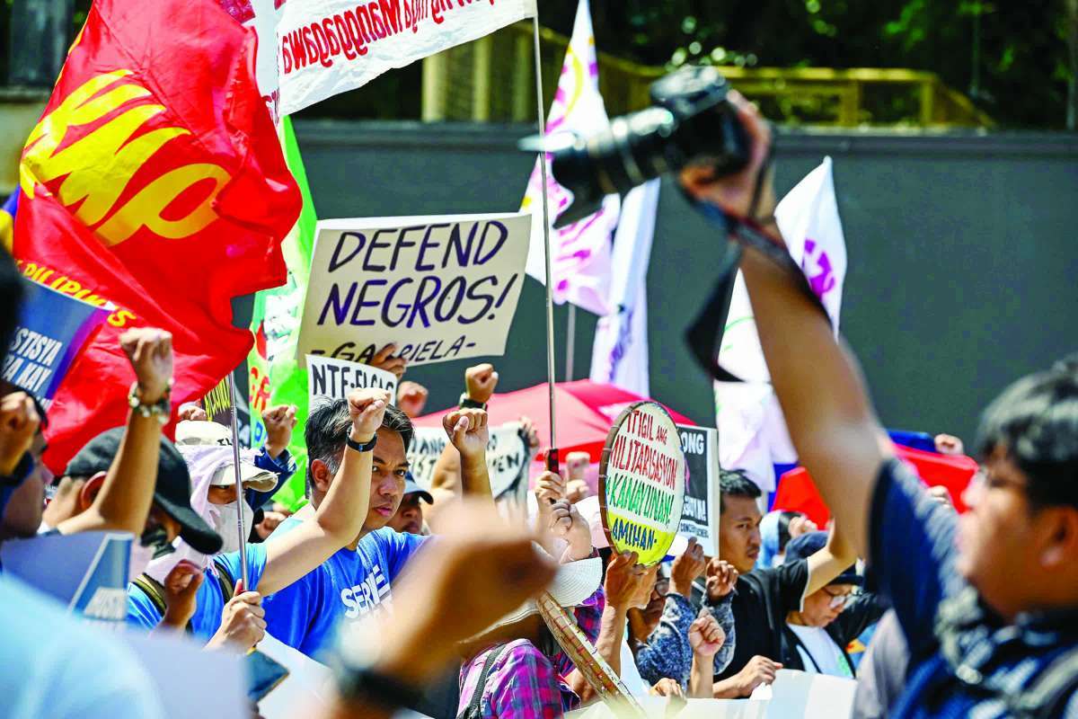 Members of Bagong Alyansang Makabayan hold a protest at Camp Aguinaldo in Quezon City on April 24, 2026, to condemn the military operation in Negros Occidental’s Toboso town that left 19 suspected rebel remnants dead. (Maria Tan / ABS-CBN News photo) 
