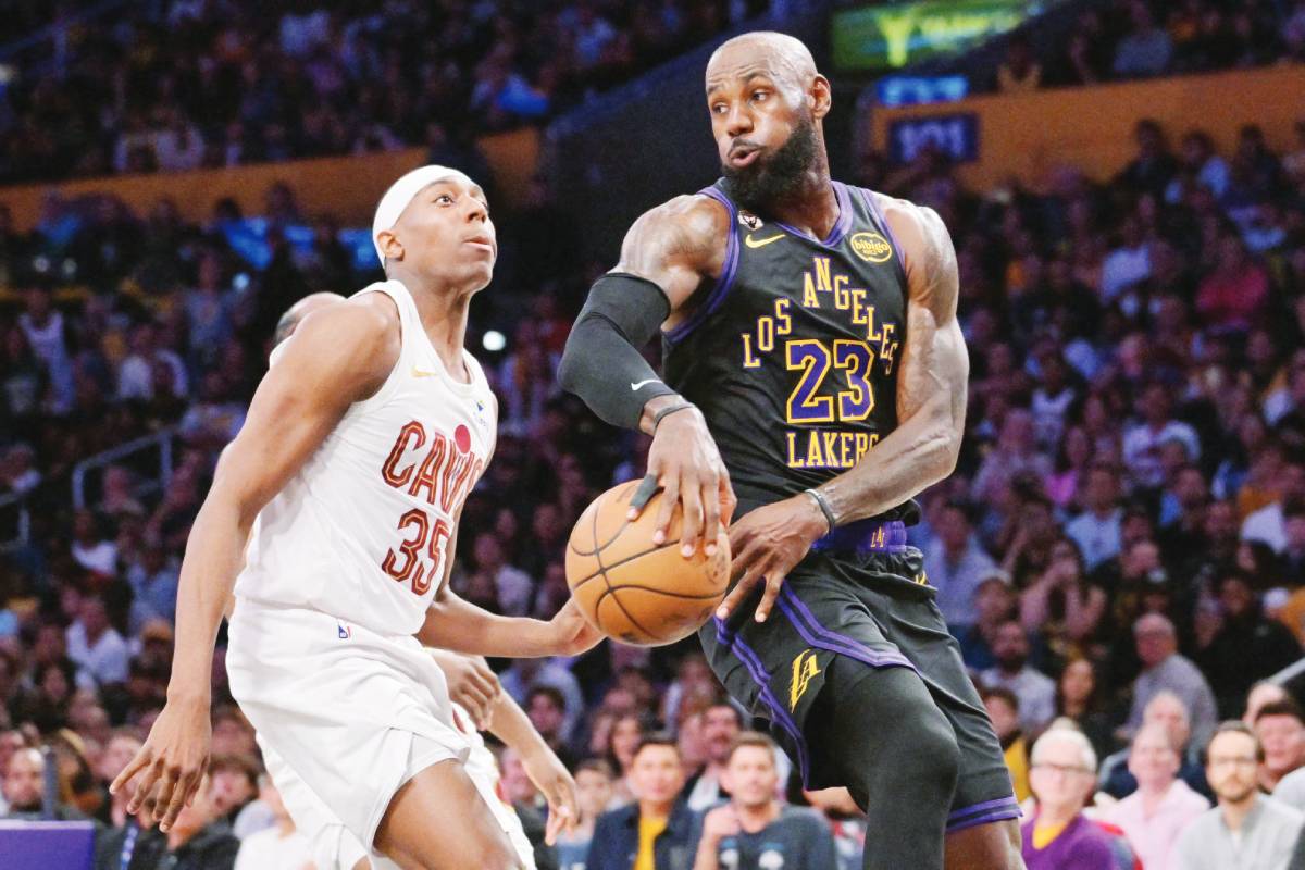 Los Angeles Lakers forward LeBron James (right) passes behind Cleveland Cavaliers forward Nae'qwan Tomlin in the first half. (Jayne Kamin-Oncea / Imagn Images / Reuters)